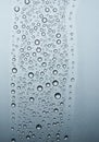 Droplets of water cover a vertical pane, creating a textured pattern against a smooth Royalty Free Stock Photo