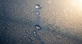 Droplets of water rest on a smooth surface, creating a pattern of variously sized droplets that Royalty Free Stock Photo
