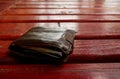 Dropped Brown Leather Man`s Wallet On Red Painted Wood Floor