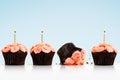 Dropped cupcake in row of cupcakes with candles on blue Royalty Free Stock Photo