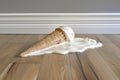 a dropped ice cream cone on a pristine acacia wood floor, melting Royalty Free Stock Photo