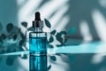 Dropper bottle of serum mockup on an abstract blue background with light and shadows