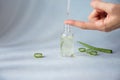 Dropper glass bottle with pipette Drop liquid essences with aloe vera dripping on woman`s hand Royalty Free Stock Photo