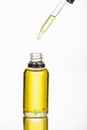 Dropper near bottler with natural serum isolated on white.