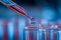 A dropper releasing a red liquid drop into a test tube in a laboratory setting with blurred blue background and precise scientific Royalty Free Stock Photo