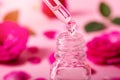 Dropper with rose flower essential oil drop over the bottle Royalty Free Stock Photo