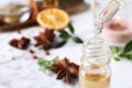 Dropping anise essential oil from pipette into bottle on table, closeup. Space for text Royalty Free Stock Photo