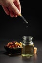 Dropping essential oil or herbal tincture into a small bottle Royalty Free Stock Photo