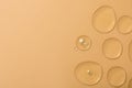 Drops of hydrophilic oil on beige background, flat lay. Space for text