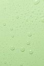 Drops of micellar water or cosmetic tonic on a green background. Close-up, macro photography