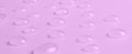 Drops of micellar water or cosmetic tonic on a pink background. Close-up, macro photography