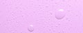 Drops of micellar water or cosmetic tonic on a pink background. Close-up, macro photography