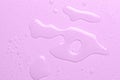 Drops of micellar water or cosmetic tonic on a pink background. Close-up, macro photography