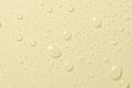 Drops of micellar water or cosmetic tonic on a yellow background. Closeup, macro photography