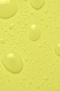 Drops of micellar water or cosmetic tonic on a yellow background. Closeup, macro photography