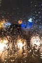 Drops on the misted glass. Blurred lights of the evening city. Focus drops on glass Royalty Free Stock Photo