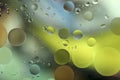 Drops of oil in water on a colored background. Bright background with yellow, blue and green circles of different sizes. Royalty Free Stock Photo