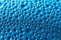 Drops of perspiration or rain on glass on a blue background. Bright background or backdrop. Macro. Selective focus