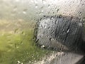 Drops of rain on the car window & x28;glass& x29; with a view of the exterior mirror and blurred background Royalty Free Stock Photo