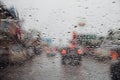 Drops Of Rain Drizzle on the glass windshield in the evening. street in the heavy rain. Bokeh Tail light and Traffic lights in cit Royalty Free Stock Photo