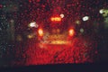 Drops Of Rain Drizzle on the glass windshield in the night. street in the heavy rain. Bokeh Tail light. soft Focus. Royalty Free Stock Photo