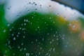 Drops of rain on glass with green tree nature background,romantic shot scene content,colorful raindrops.Blurred leaves of trees Royalty Free Stock Photo