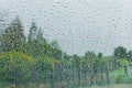 Drops of rain on the window; blurred trees in the background; shallow depth of field Royalty Free Stock Photo