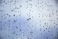 Drops of rain on a window glass. Beautiful blue cloudy sky in background Royalty Free Stock Photo