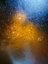 Drops of rain on window at night. Rainy and night city behind  glass. Tears of the sky flow down  transparent wall. Bead drops Royalty Free Stock Photo