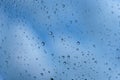 Drops of rain on a window pane. Shallow depth of field. Selective focus. Blue tone Royalty Free Stock Photo