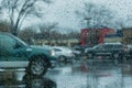 Drops of rain on the window; parked cars in the background; shallow depth of field Royalty Free Stock Photo