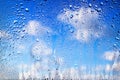 Drops of rain on the window. Water drops on glass. Abstract background. Blue sky with clouds. Texture of drops. Selective focus Royalty Free Stock Photo