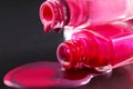 drops of red bearded pink nail polish flow from the bottle of the bottle on a black dark background with a copyspace Royalty Free Stock Photo