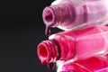 drops of red bearded pink nail polish flow from the bottle of the bottle on a black dark background with a copyspace Royalty Free Stock Photo