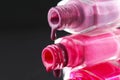 drops of red bearded pink nail polish flow from the bottle of the bottle on a black dark background with a copyspace Royalty Free Stock Photo