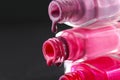 drops of red bearded pink nail polish flow from the bottle of the bottle on a black dark background with a copyspace Royalty Free Stock Photo