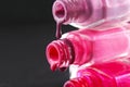 drops of red bearded pink nail polish flow from the bottle of the bottle on a black dark background with a copyspace Royalty Free Stock Photo