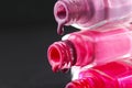 Drops of red bearded pink nail polish flow from the bottle of the bottle on a black dark background with a copyspace Royalty Free Stock Photo