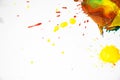 Drops of red, yellow and green paint are sprayed on a white background and the leaves of a tree. Royalty Free Stock Photo