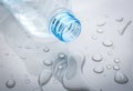 Drops of spilled water and plastic bottle on grey background, closeup Royalty Free Stock Photo