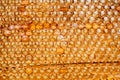 Drops of thick golden honey flowing along the frame of honeycombs. Honey pouring and dripping along honeycomb cells in