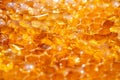 Drops of thick golden honey flowing along the frame of honeycombs. Honey pouring and dripping along honeycomb cells in