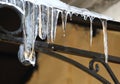 Drops of water fall from melting icicles