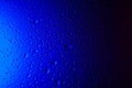 Drops of water on glass in blue neon light. Rain on the glass against the background. Abstract photo for background. light. Rain Royalty Free Stock Photo