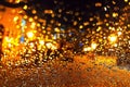Drops of water on glass of car in winter evening and reflection of glare from streetlights. Bokeh.