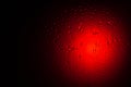 Drops of water on glass in red neon light. Rain on the glass against the background of colored lights. Royalty Free Stock Photo