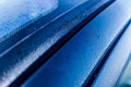 Drops of water on the metallic surface of a blue car after washing it, detail Royalty Free Stock Photo