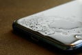 Drops of water, moisture or dew on the screen of a modern phone - smartphone. The concept of the degree of moisture protection of Royalty Free Stock Photo