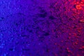 Drops of water on a textural surface in neon light. Reflection of red-blue light in drops of water. Royalty Free Stock Photo