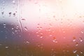 Drops of water on window glass after rain with dramatic blurred sunset on background. Idyllic tranquil nature wallpaper